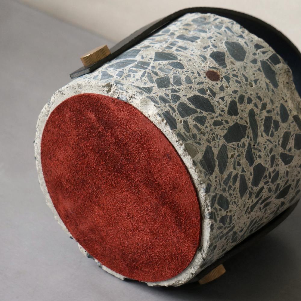 Underneath view of the concrete doorstop. A layer of red suede underneath prevents the doorstop from sliding